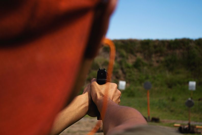 Man Shooting Pistol At Outdoor Shooting Range