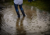 Person standing in water in rubber boots due to a burst pipe.