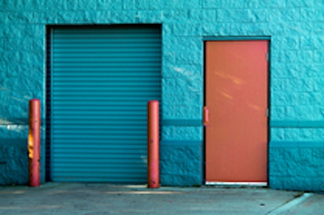 Blue security shutters covering a door set into a painted blue stone wall.
