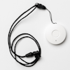 A medical button attached to a black necklace on a white background.