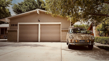 House With Brown Garage and Vintage Vehicle