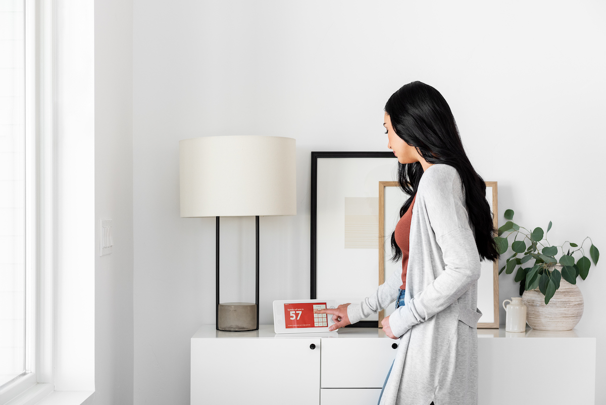 Woman Interacting With Home Security Alarm Panel