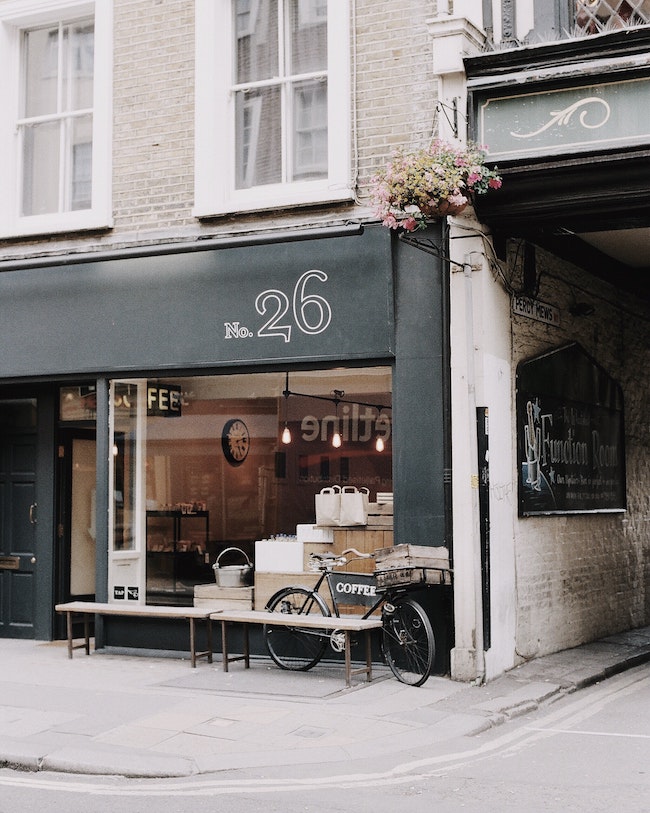 A small storefront with large windows and a bicycle propped up in front of it.