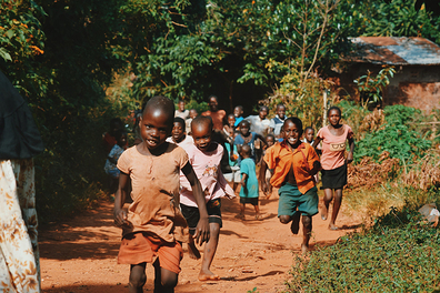 Children running happily in Africa where it is sometimes hard to find fresh water.