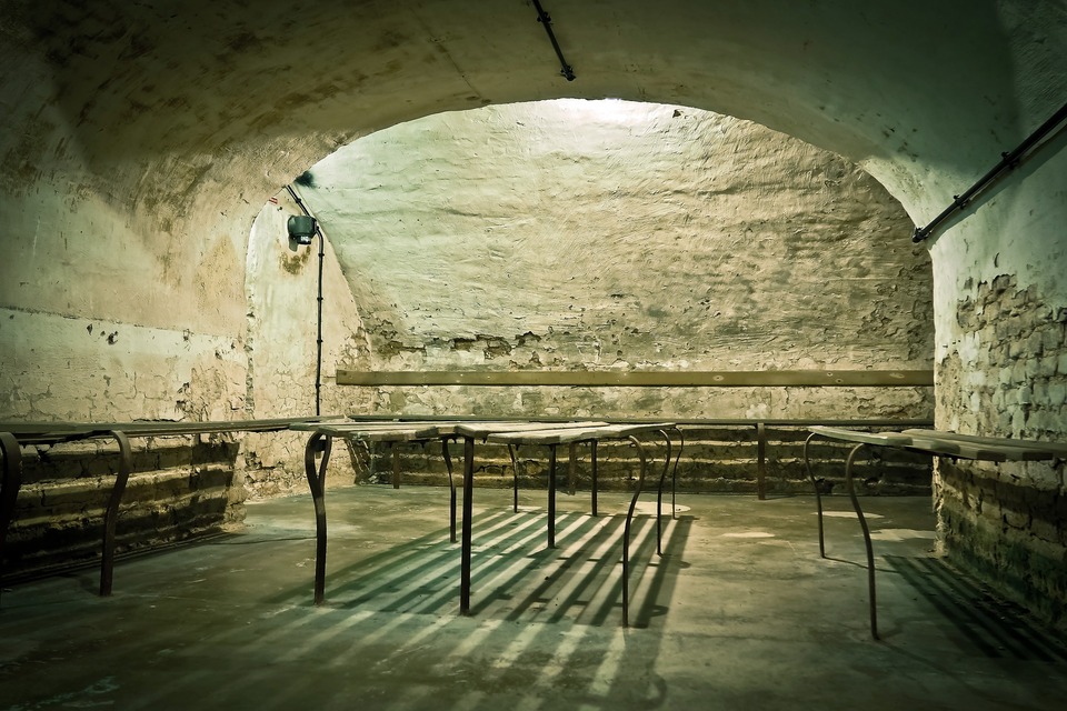 A bomb shelter with an arched ceiling, benches line the room