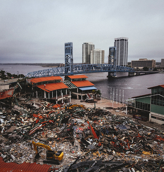 In the foreground are buildings that have been completely obliterated by an earthquake. Unharmed skyscrapers in background.