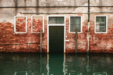 Front of a red brick house that has been flooded. 