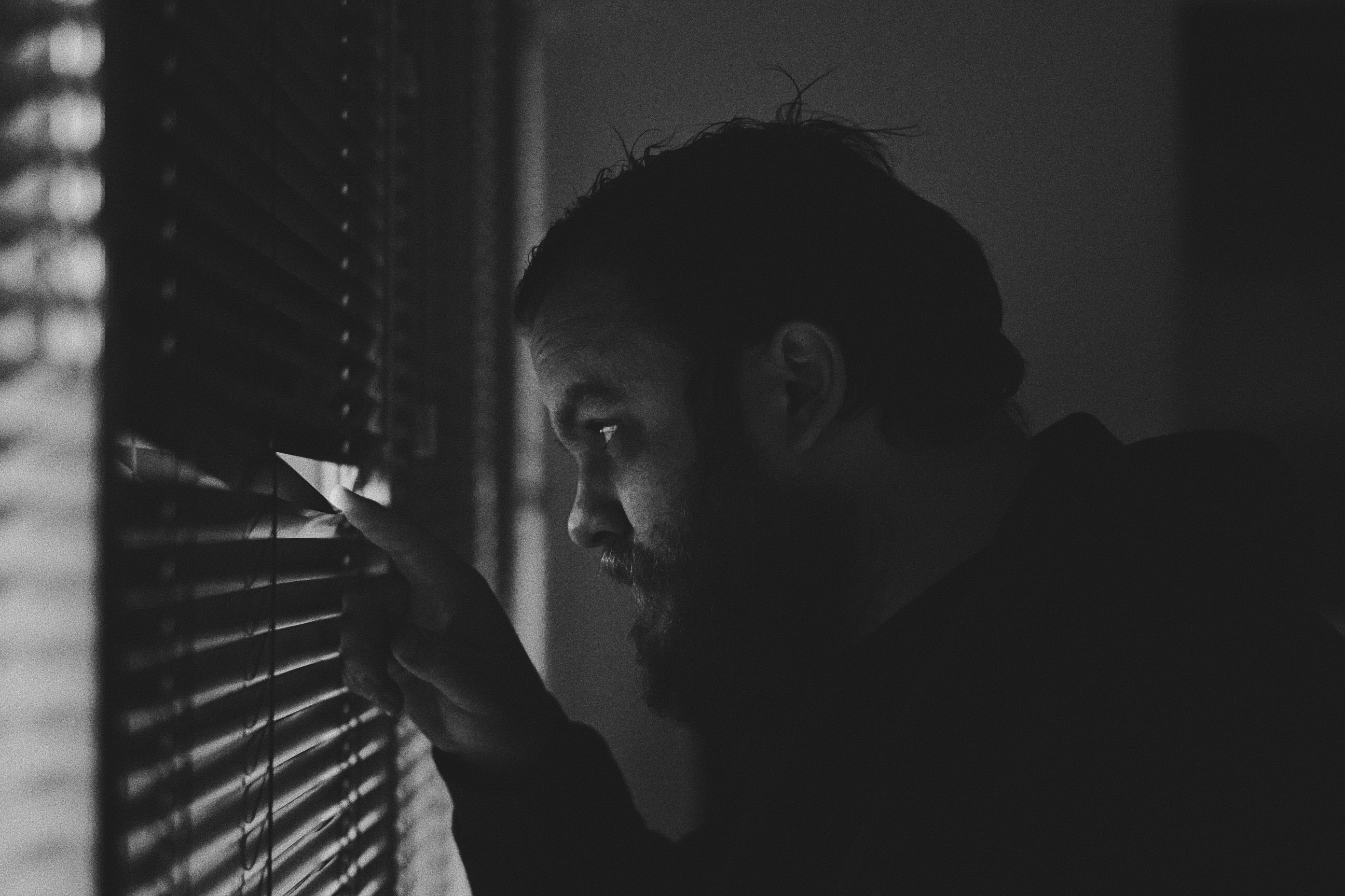 Man peeking through blinds