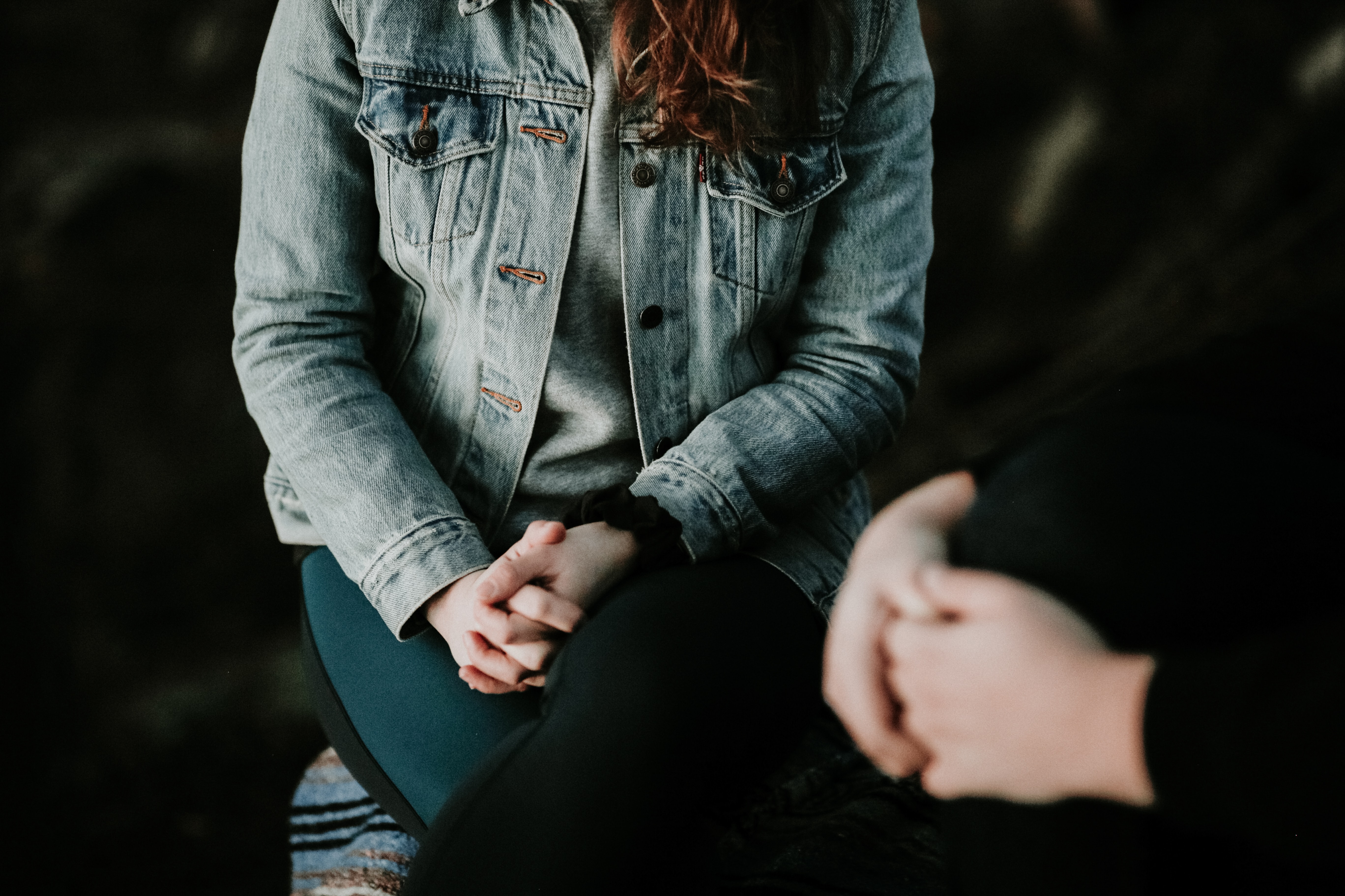 Two people sitting talking, their hands in focus.