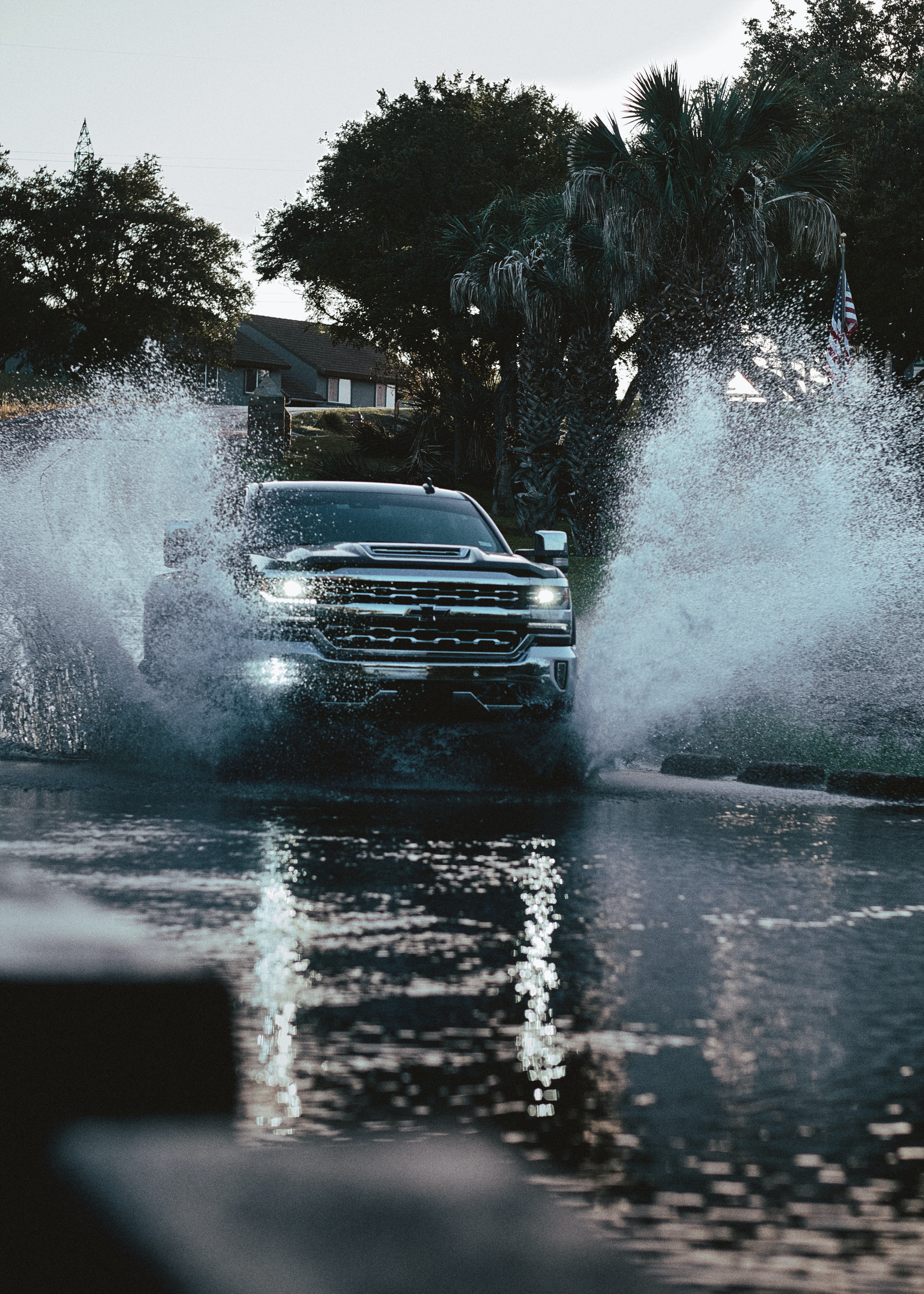 Truck driving through flood waters.