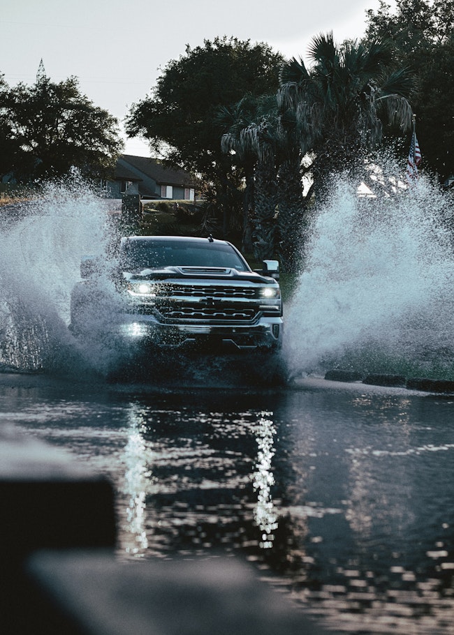 Truck driving through flood waters.