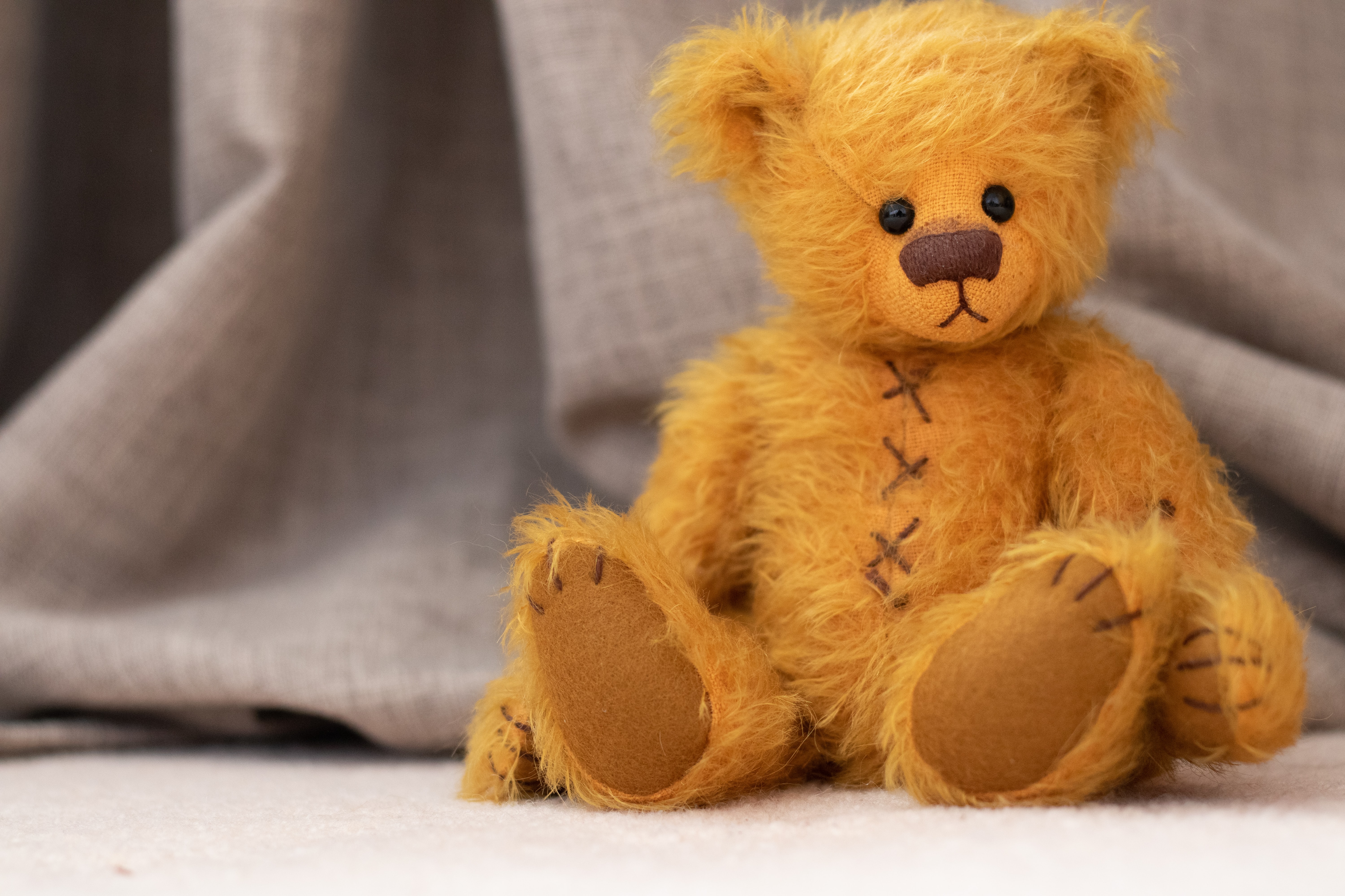 Cute teddy bear with brown stitching.