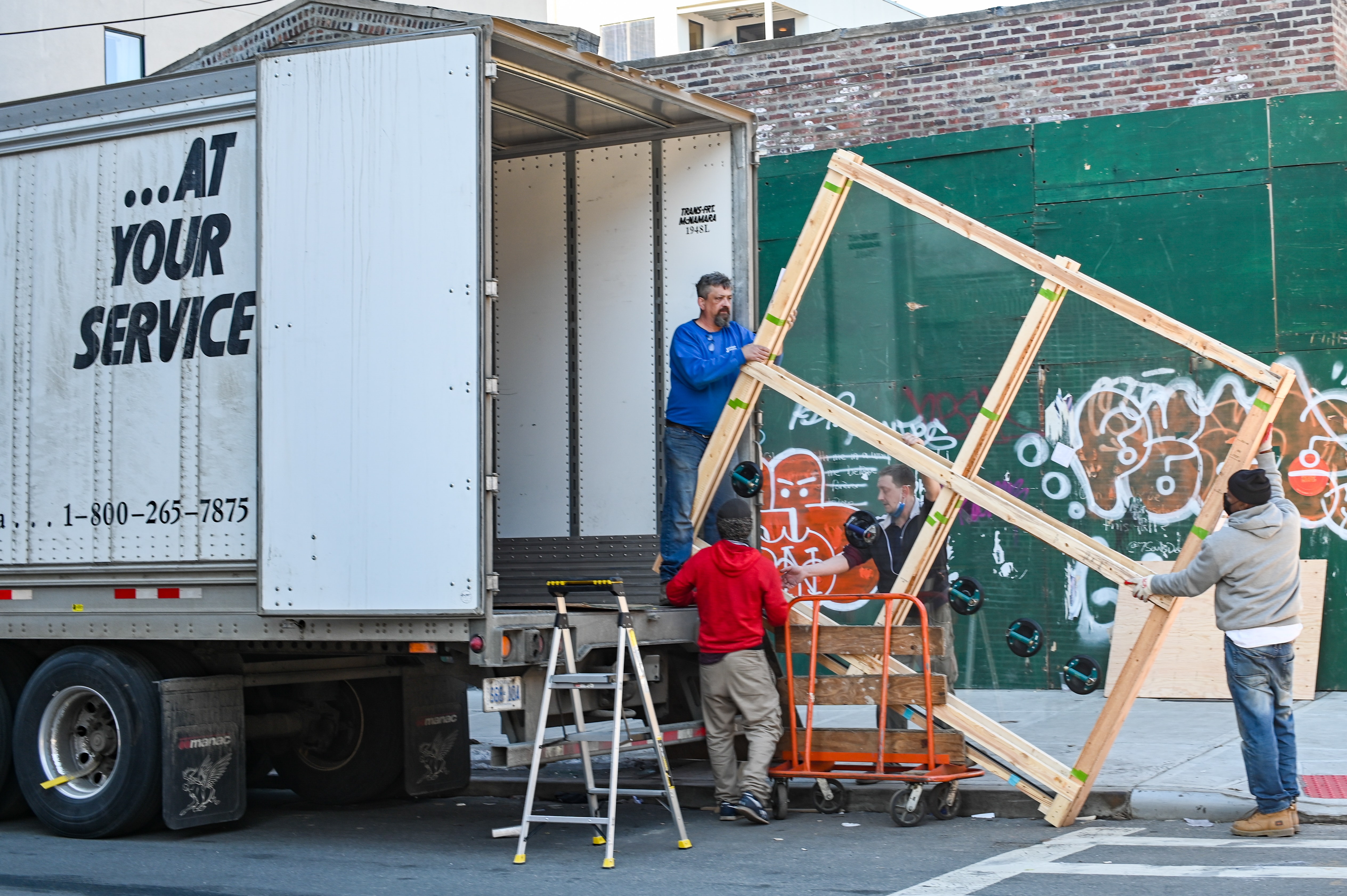 Four people moving items into a moving truck.