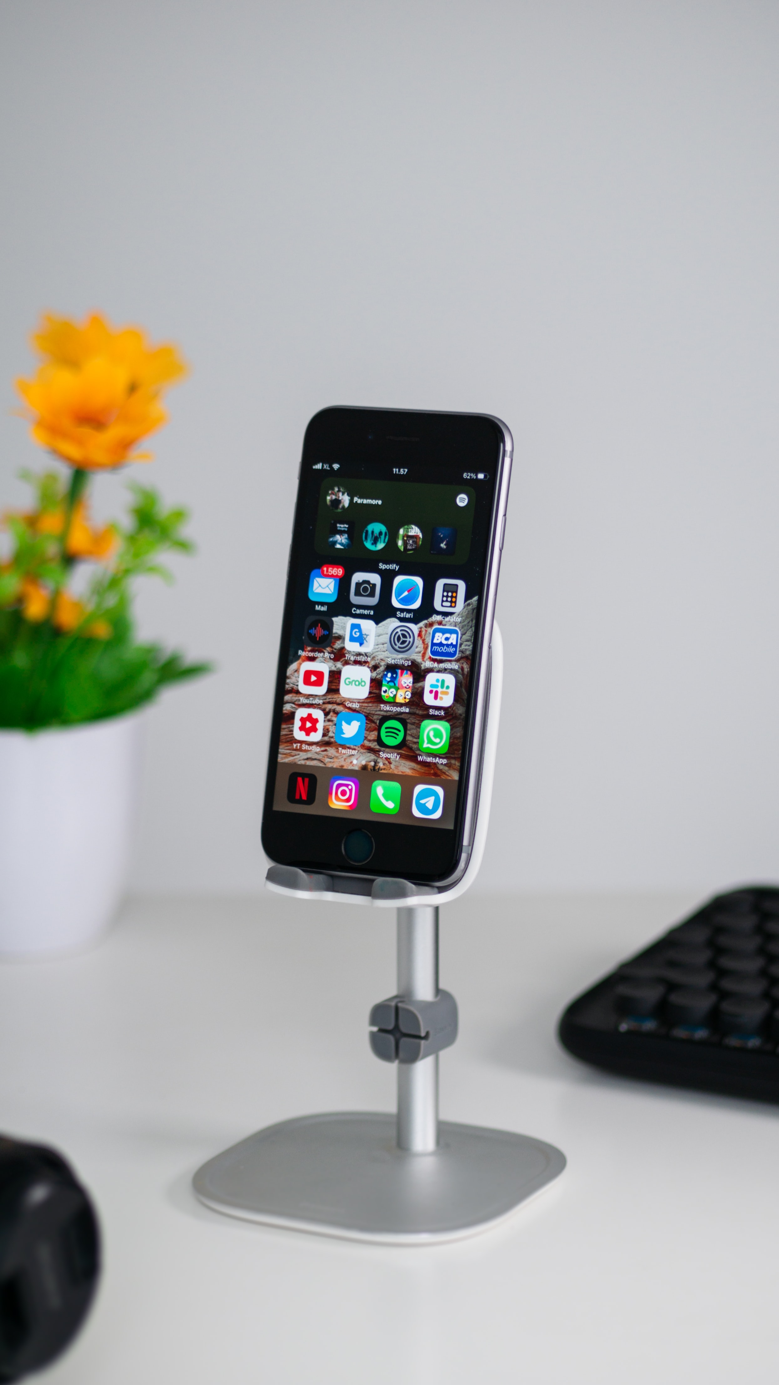 Smart phone mounted on a stand on a desk.