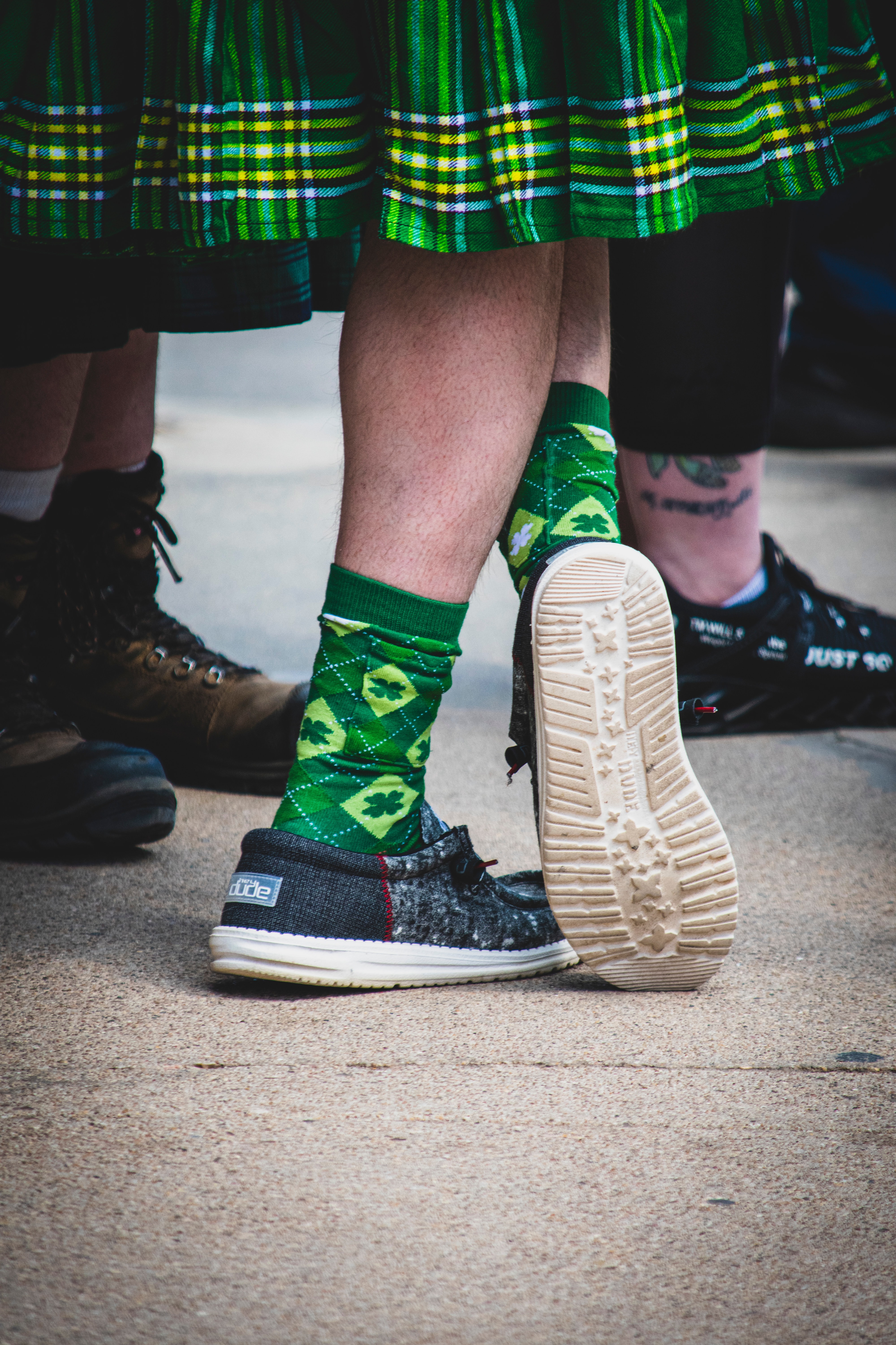 Man wearing a green kilt and shamrock socks.