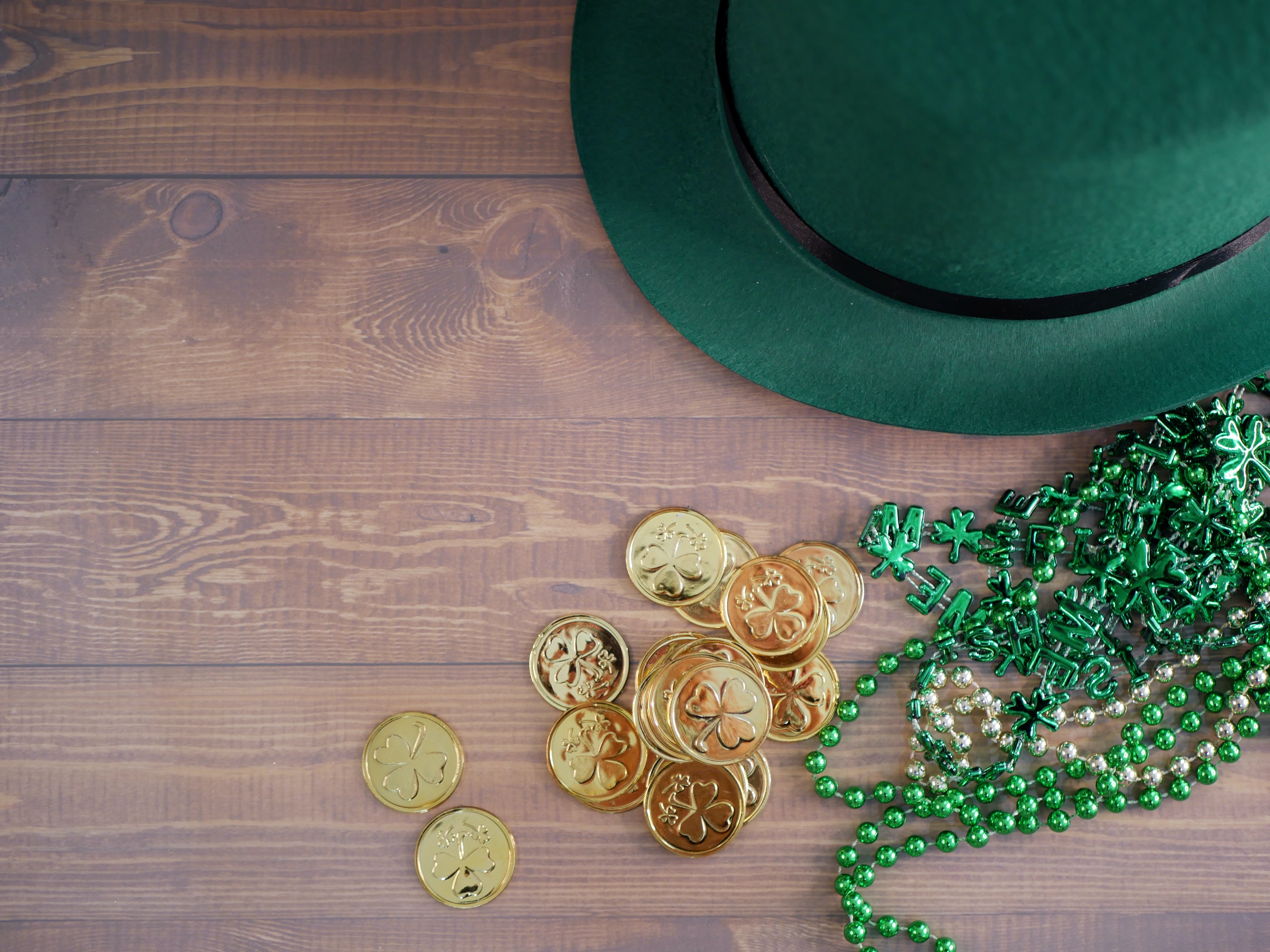 Green St. Patrick's Day hat, green necklaces, and shamrock coins.