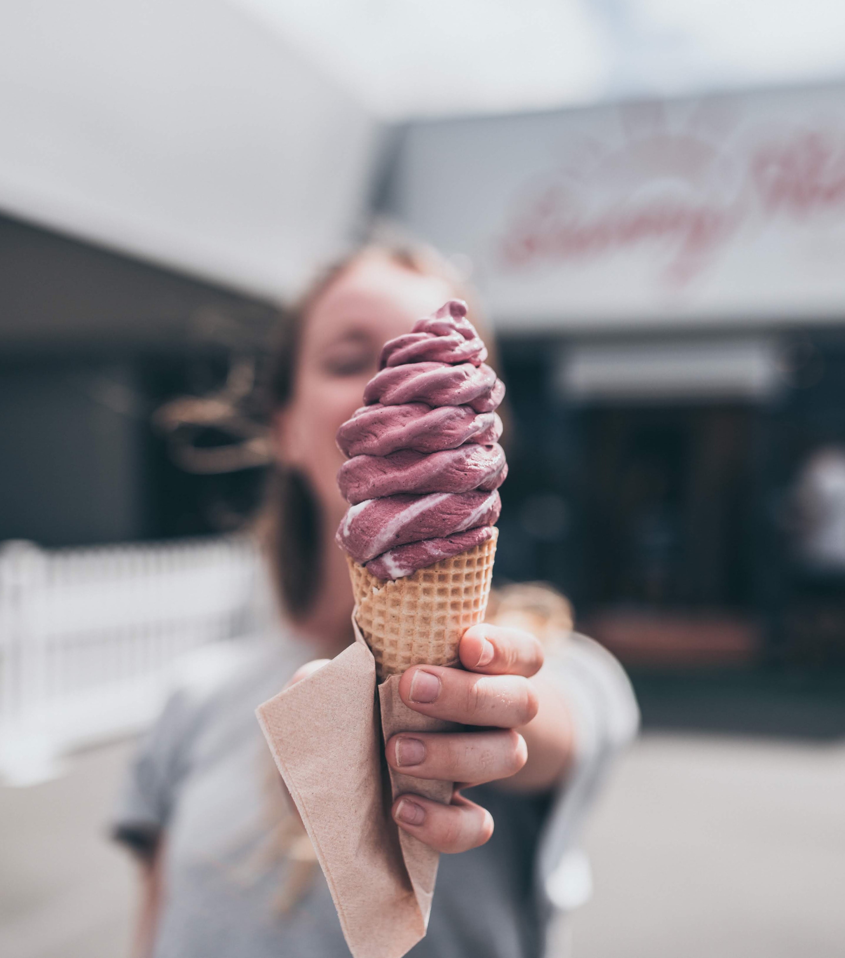 Woman holding an ice cream cone with purple ice cream.