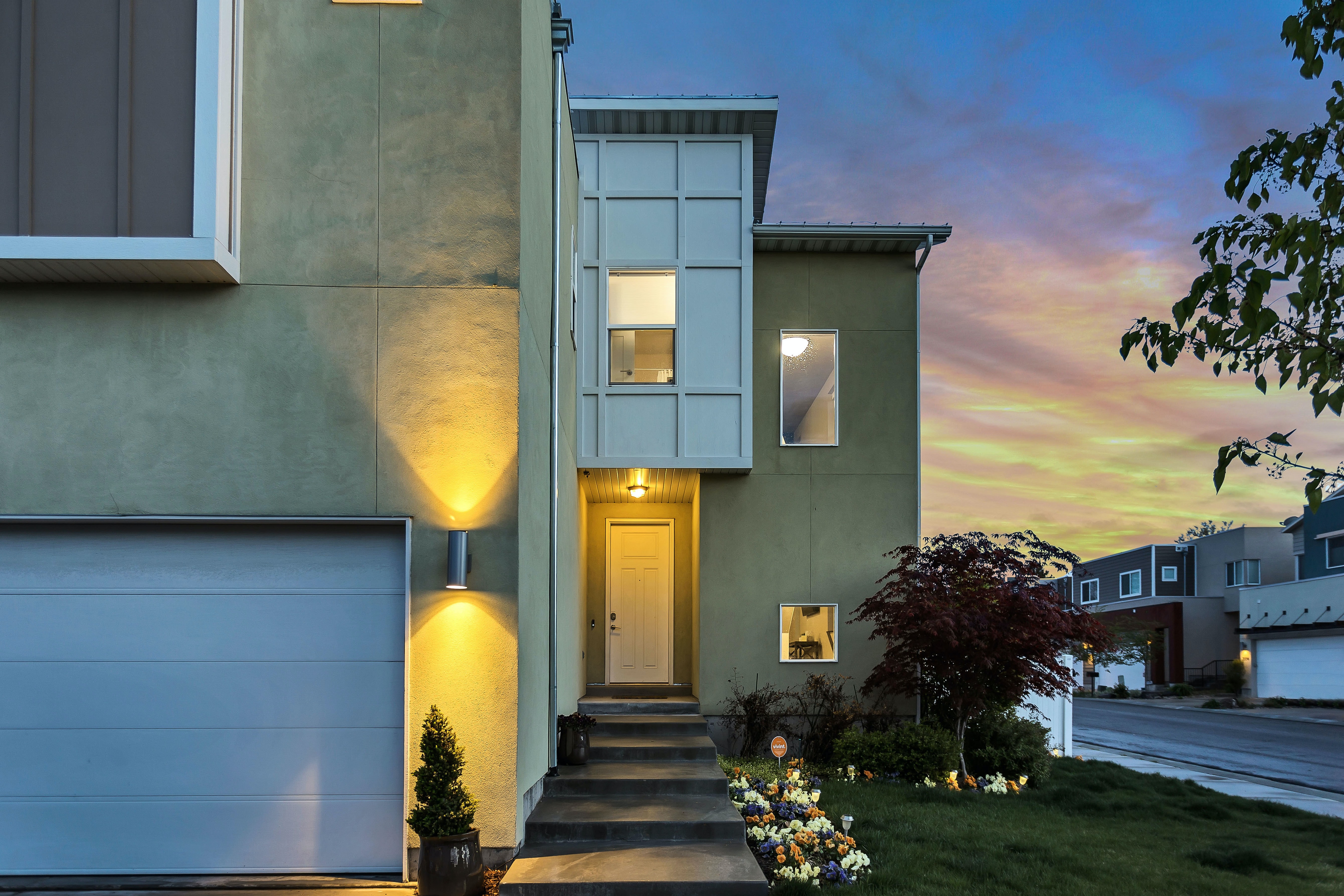 House at sunset with outside lights on.