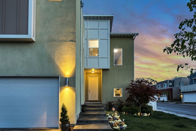 House at sunset with outside lights on.