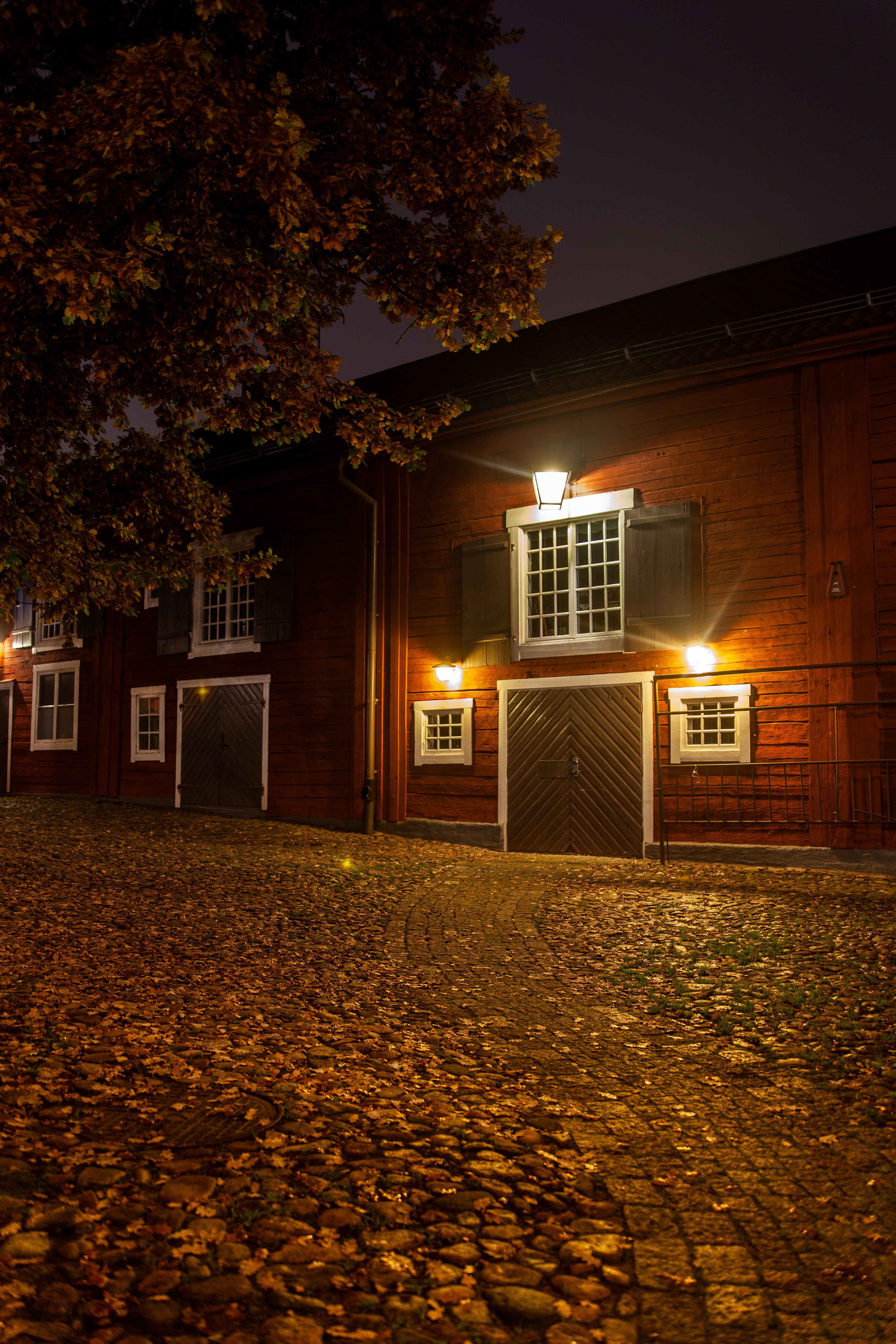 Red house garage with outside lights over the windows.