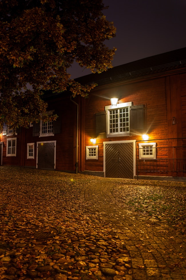 Red house garage with outside lights over the windows.