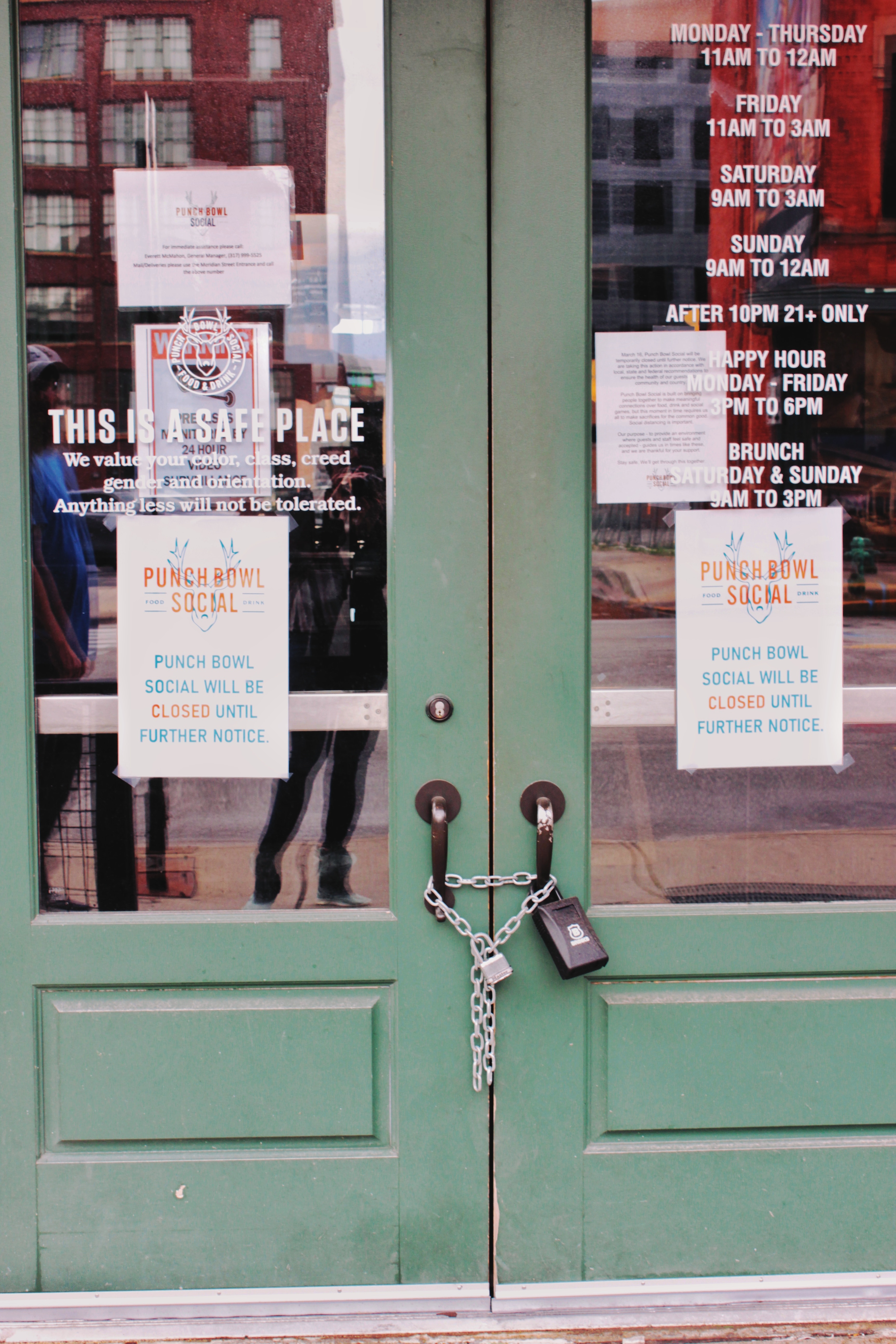 Store front with green doors locked shut with a chain and padlock.