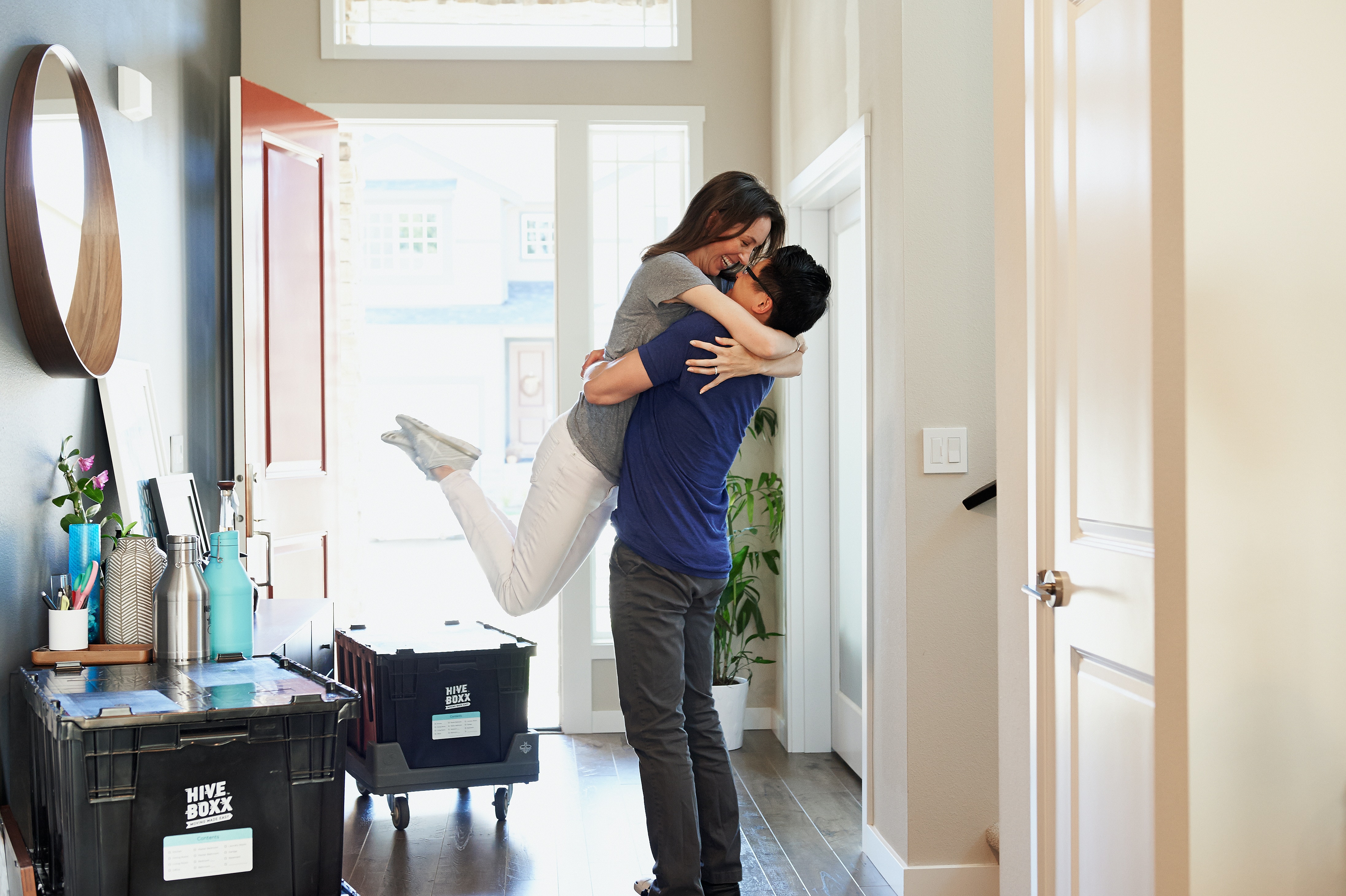 Man and woman hugging and happy about moving into a new house with crates.