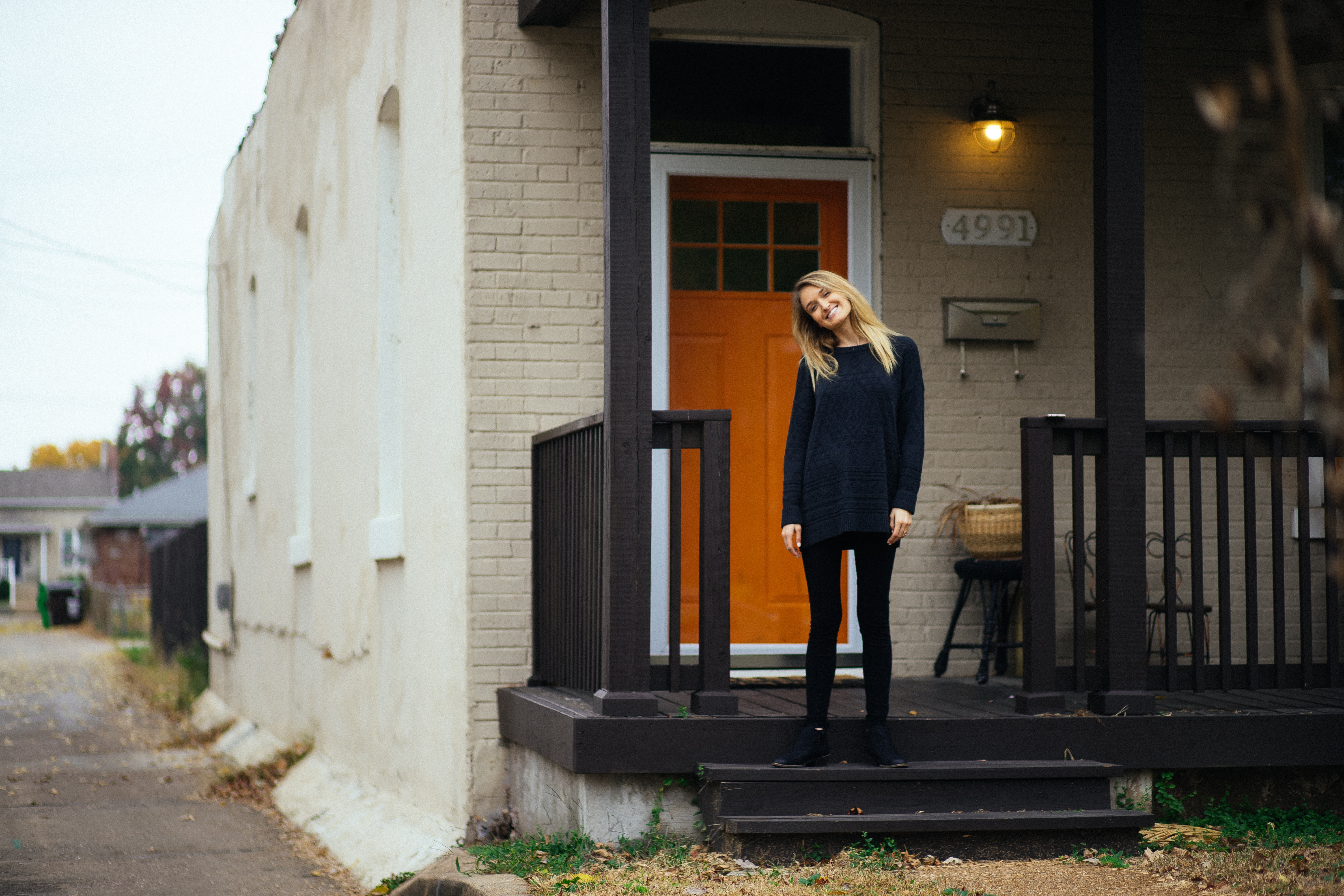 Woman standing in front of the front door of her home.