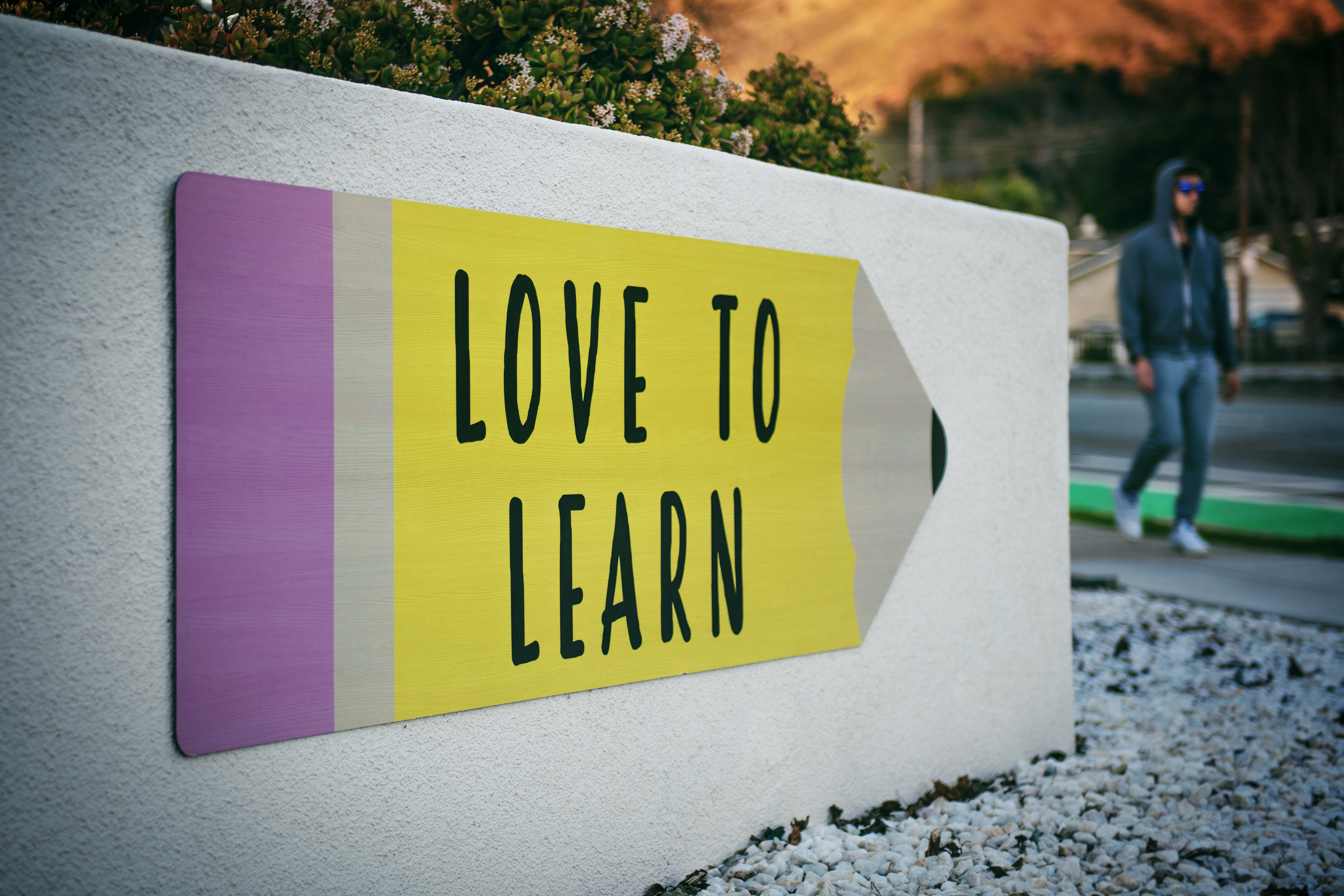 Love to Learn sign in the shape of a pencil at a school.