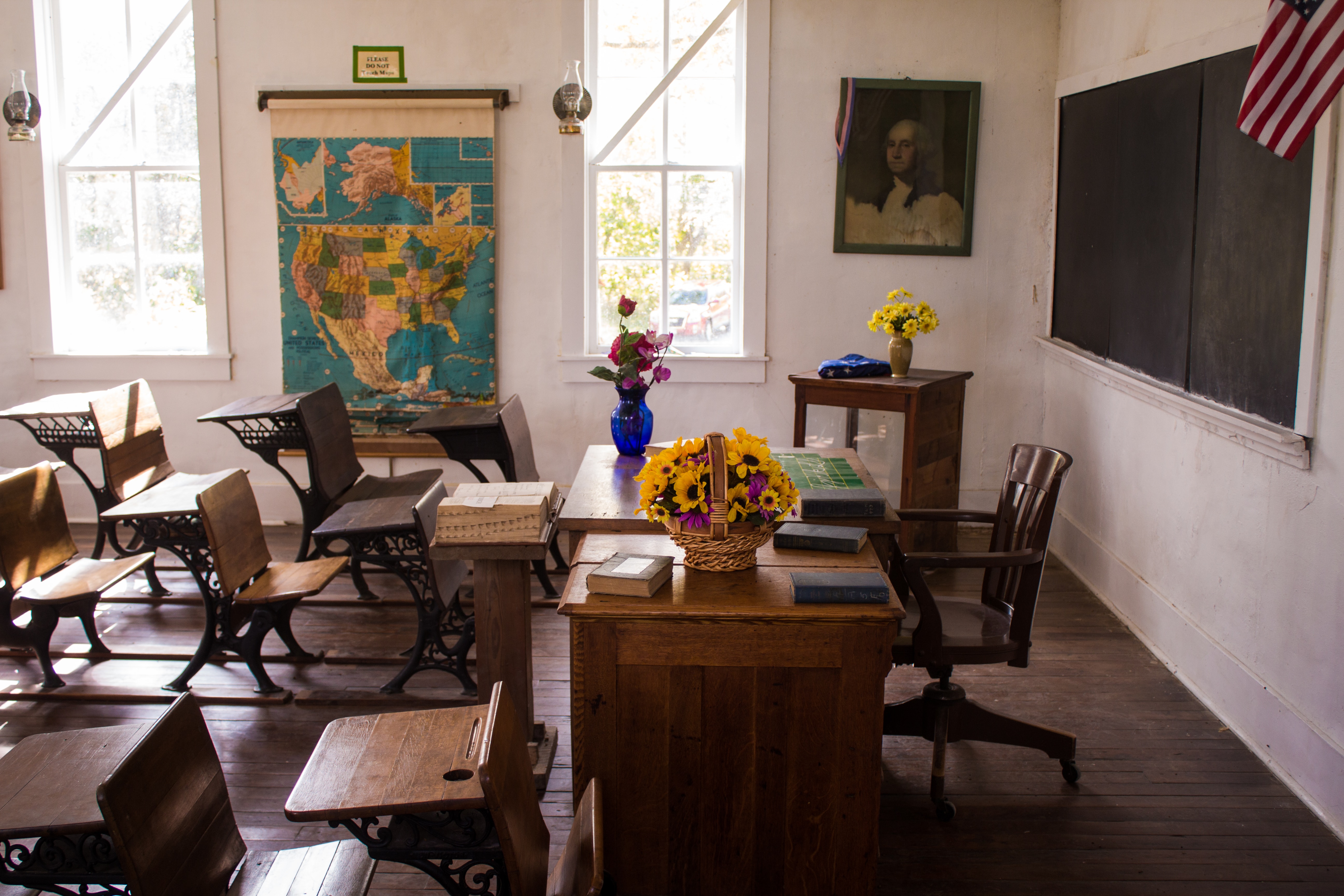 Classroom with desks, blackboard, map, flag, etc.