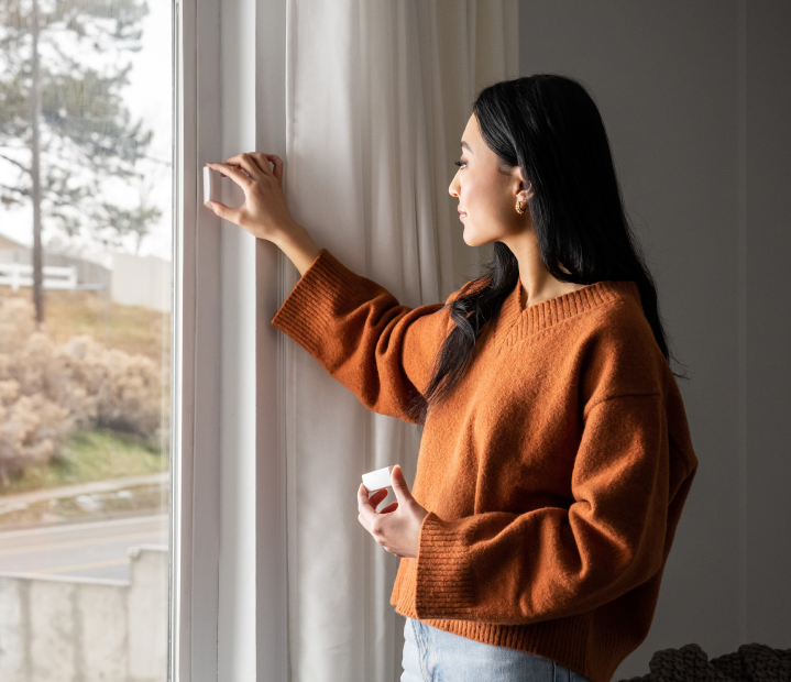 Woman installing a window sensor