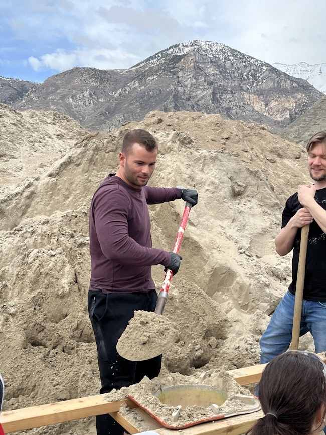 Cove employee fills a sandbag using a shovel.