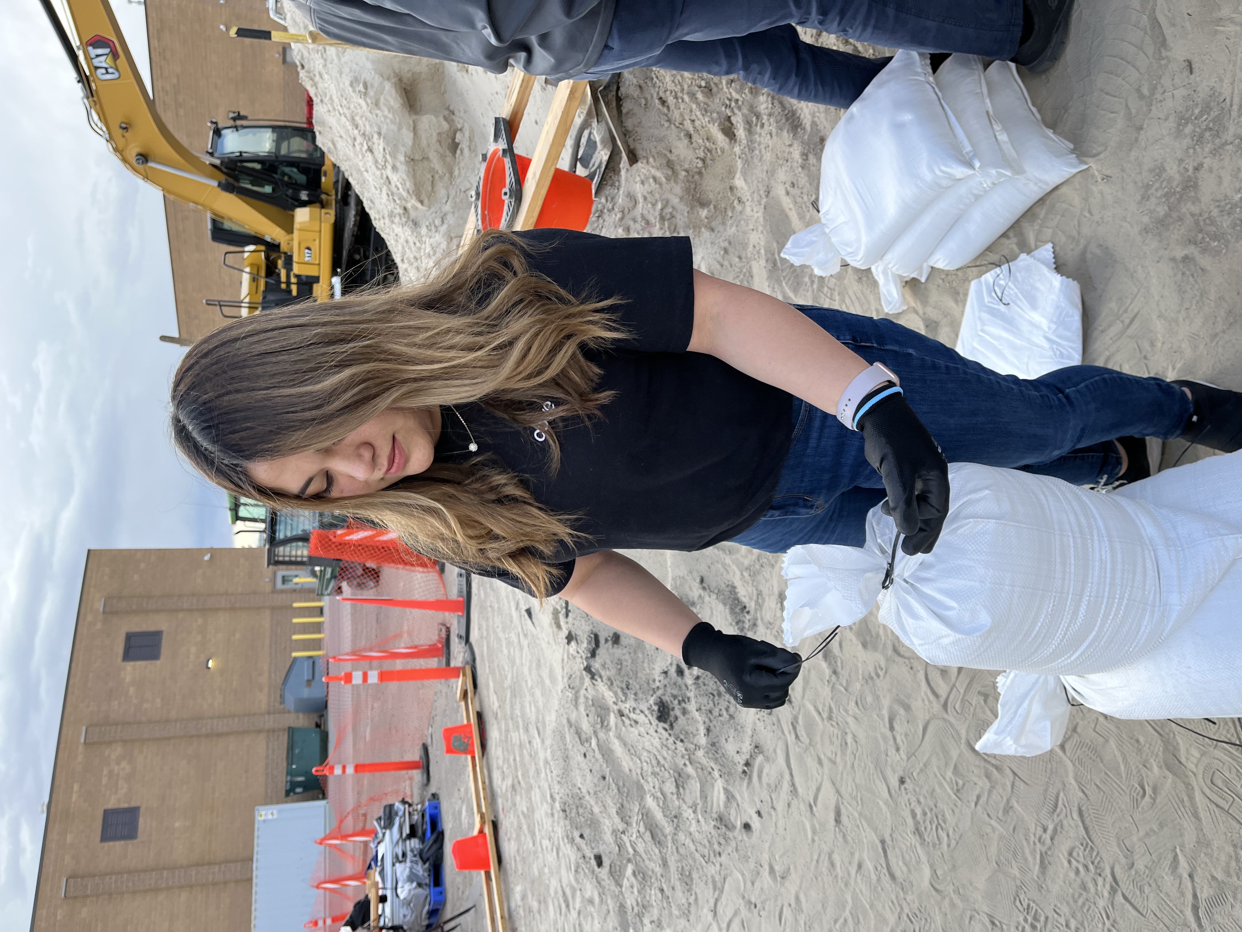 Tying a sandbag to help prevent flooding.