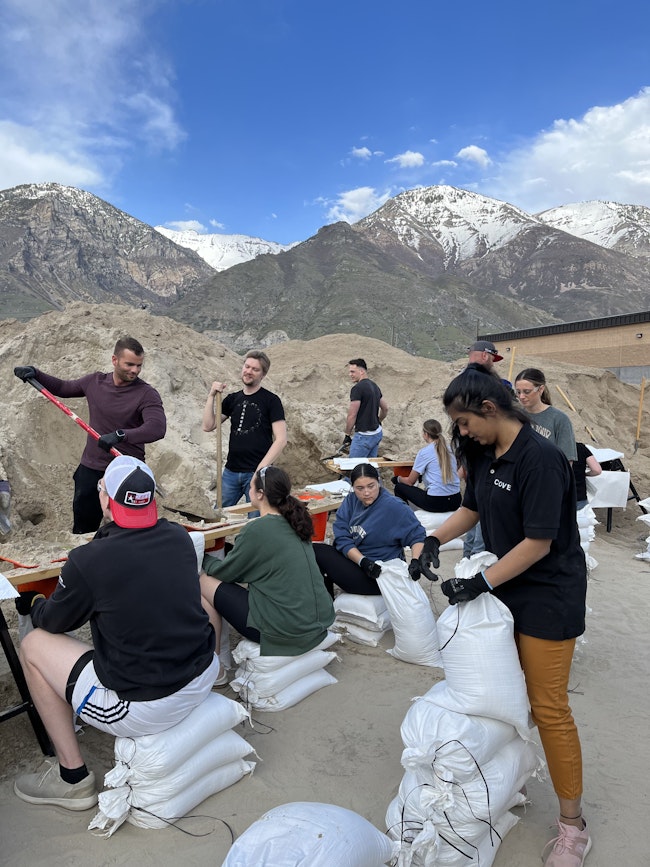 People in the Utah County community serve by filling sandbags.