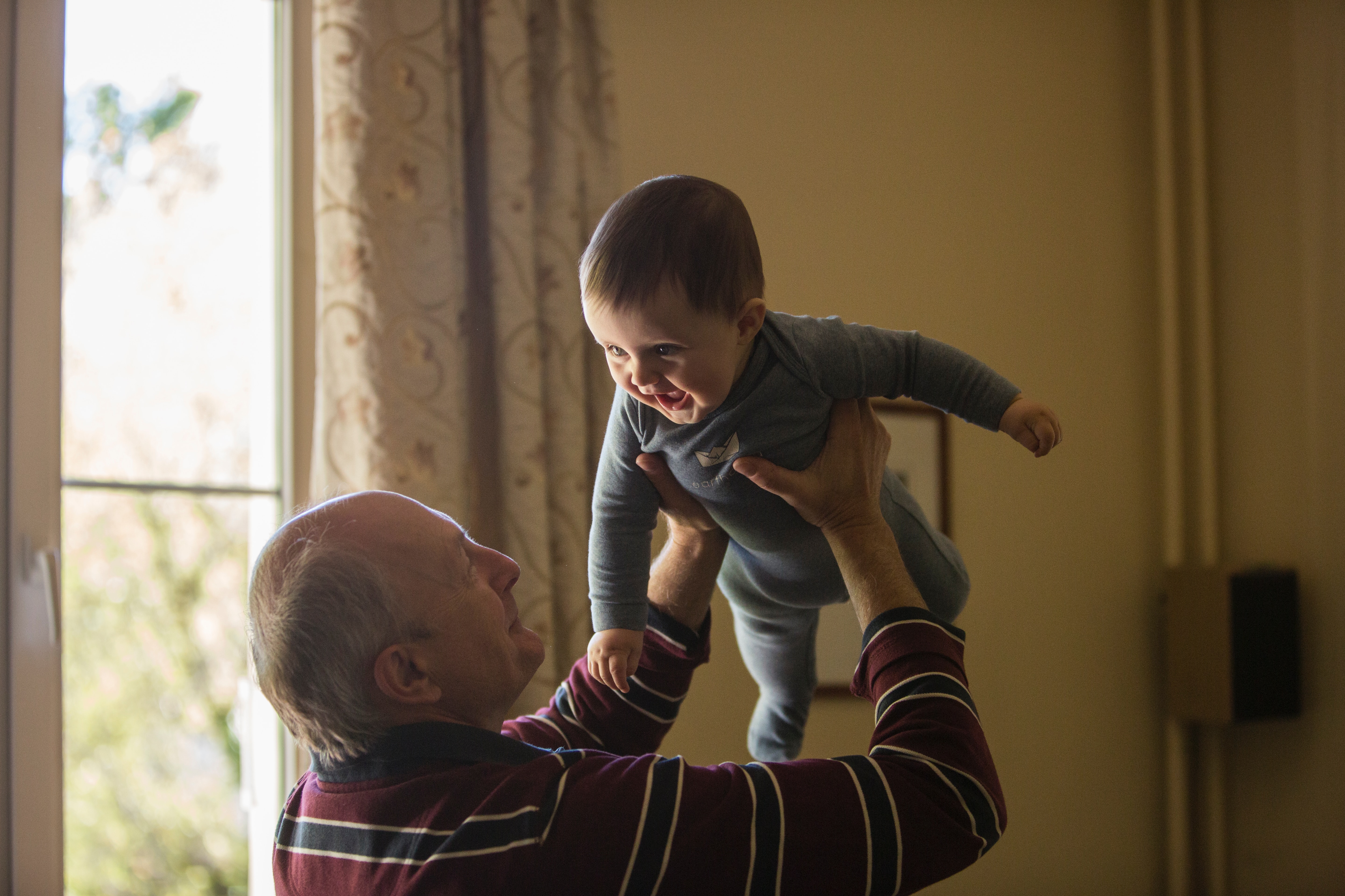 A grandpa playing with his young grandson.