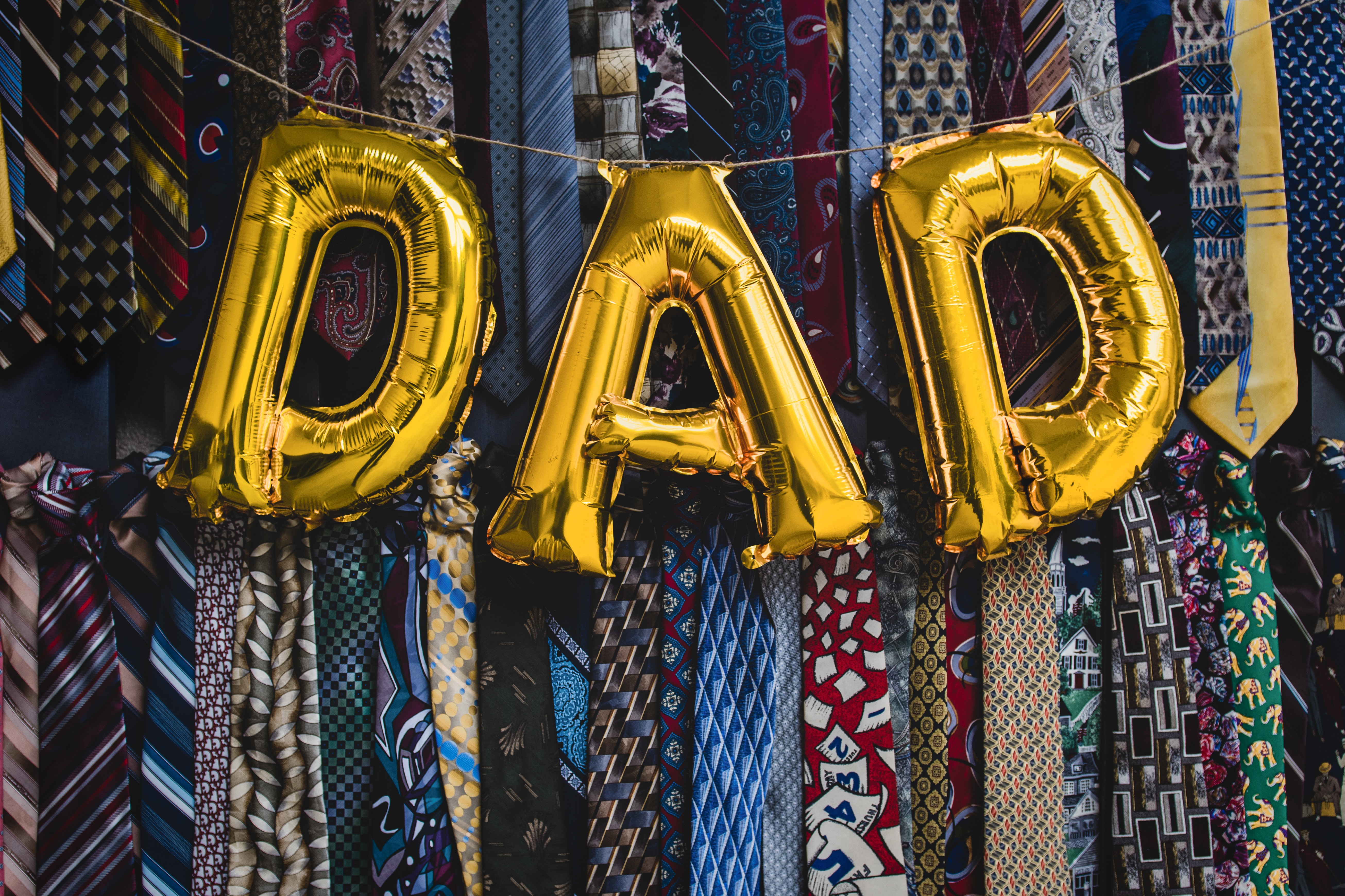 DAD letter balloons hanging over a bunch of neckties.