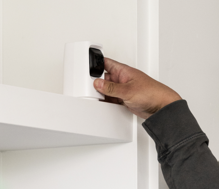 a guy putting a camera on the shelf