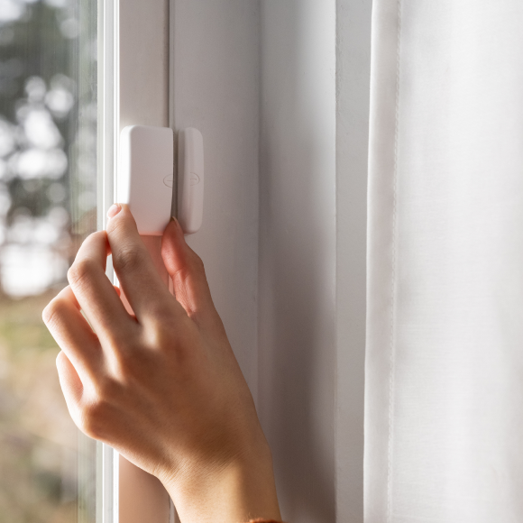 person placing window sensor