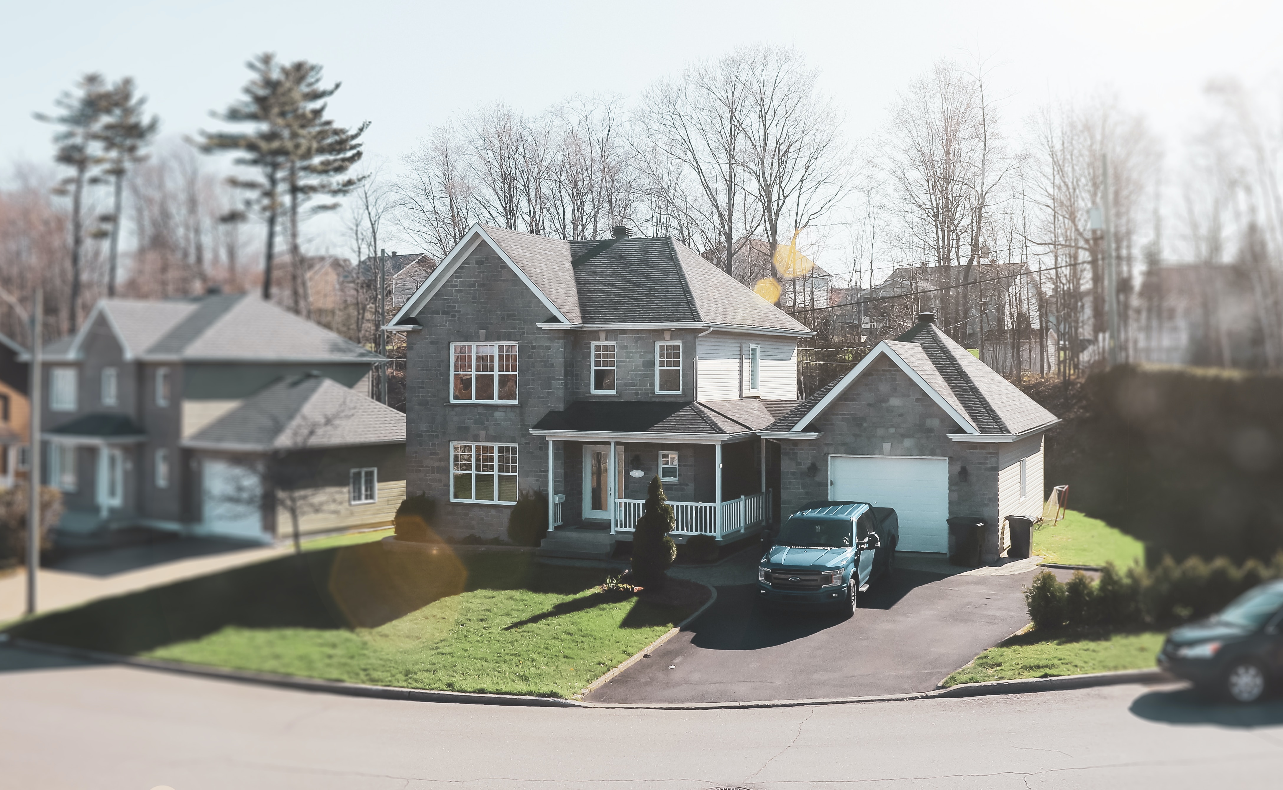 Two-level home with a garage and truck in the driveway located in a nice neighborhood.