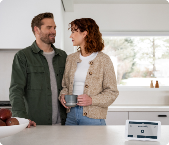 Man and woman in kitchen with alarm display