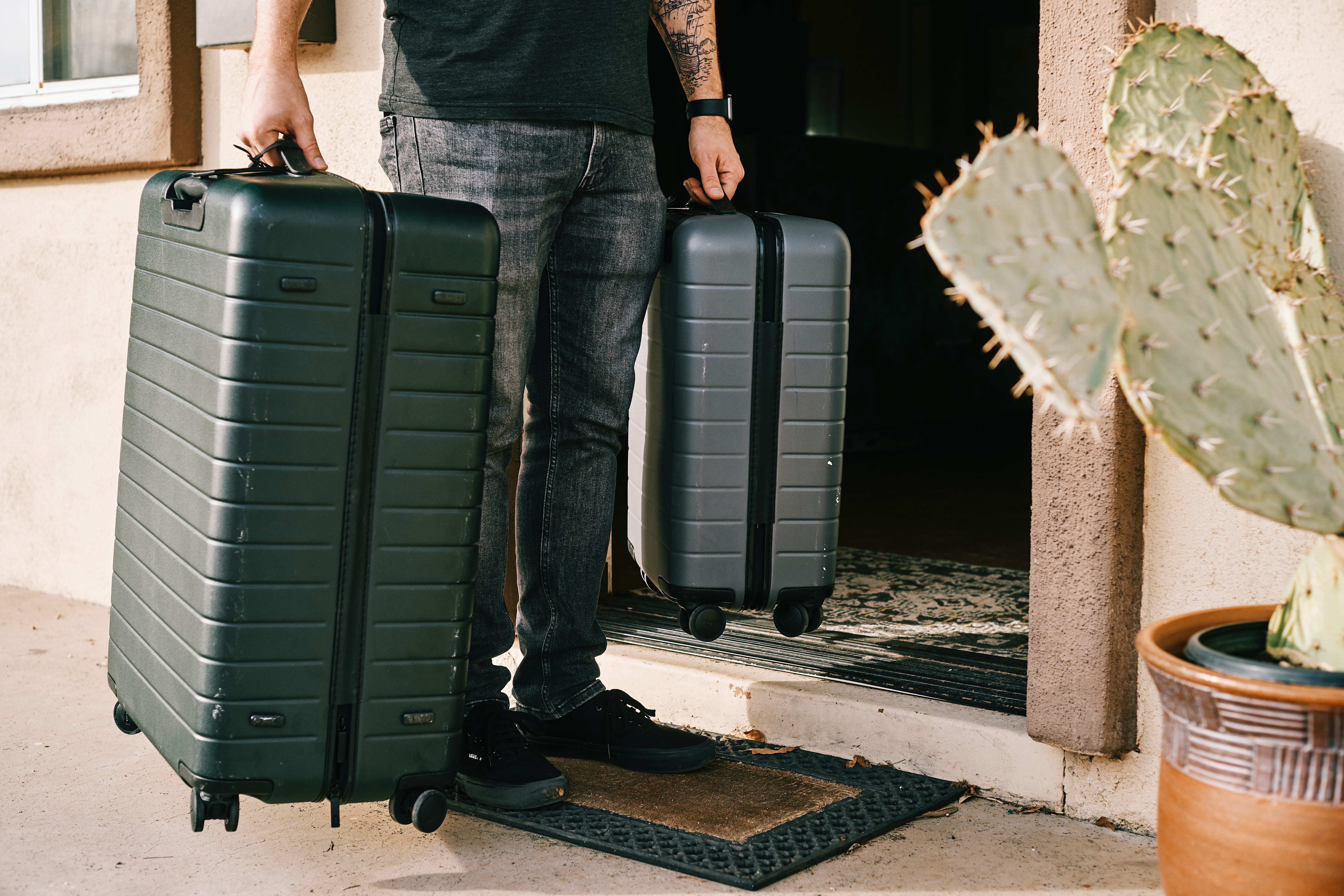 A guest comes through the front door with luggage.