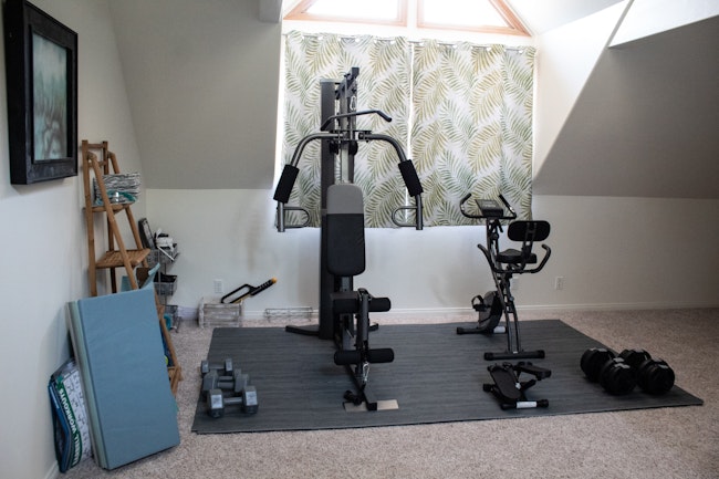 Home gym set up with a bike and weight lifting equipment.