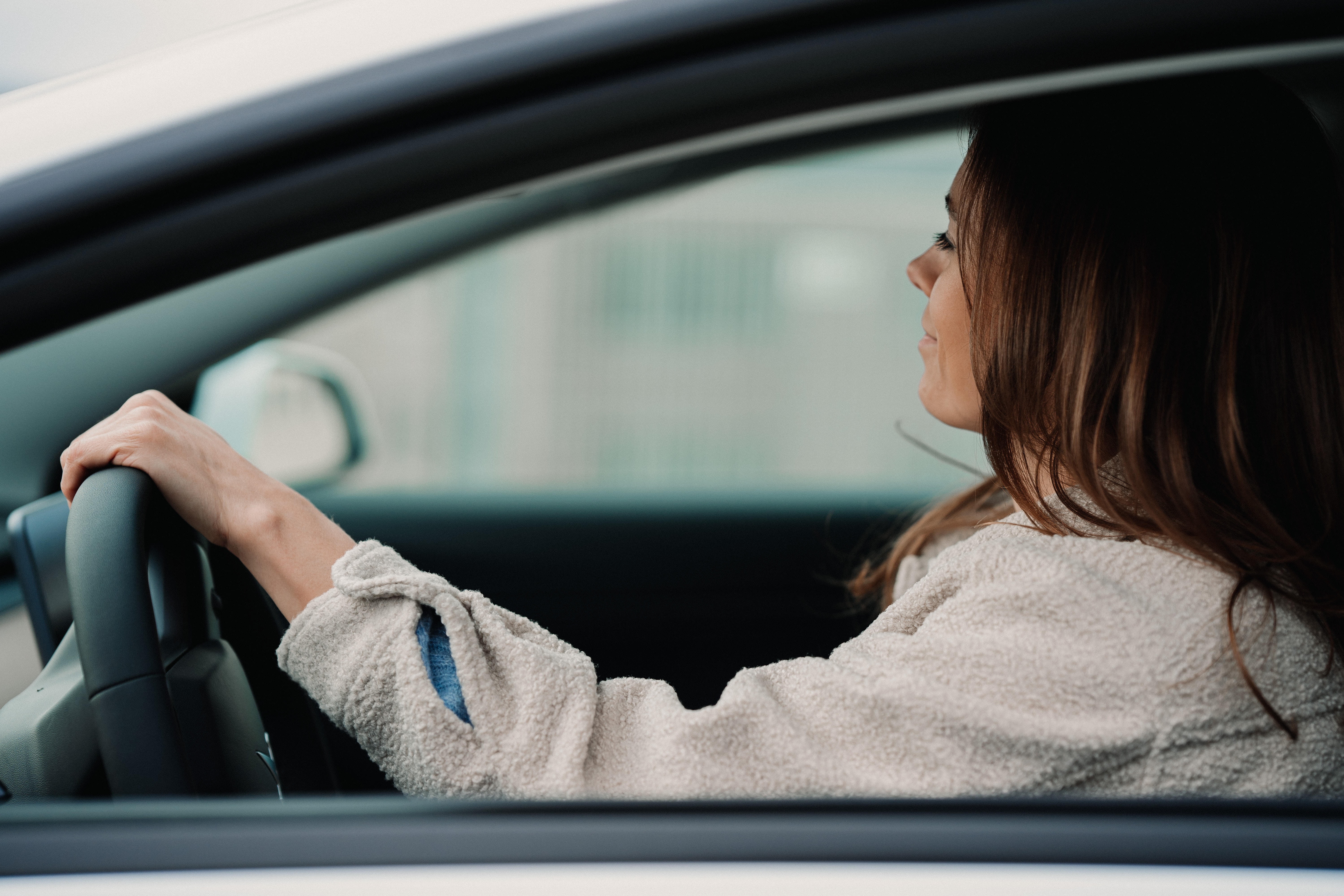 A young woman driving a car.