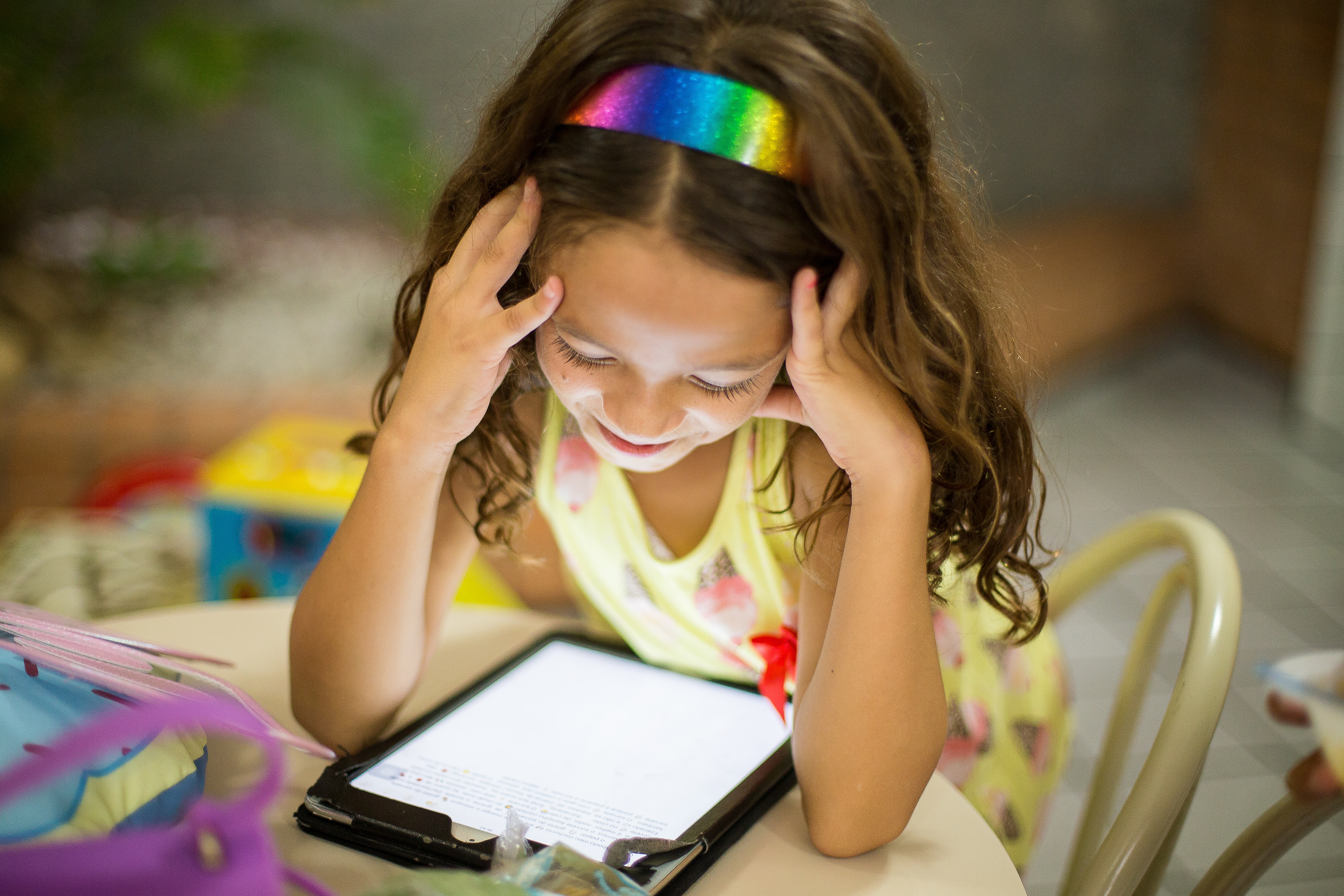Young school student using a device with apps for homework.