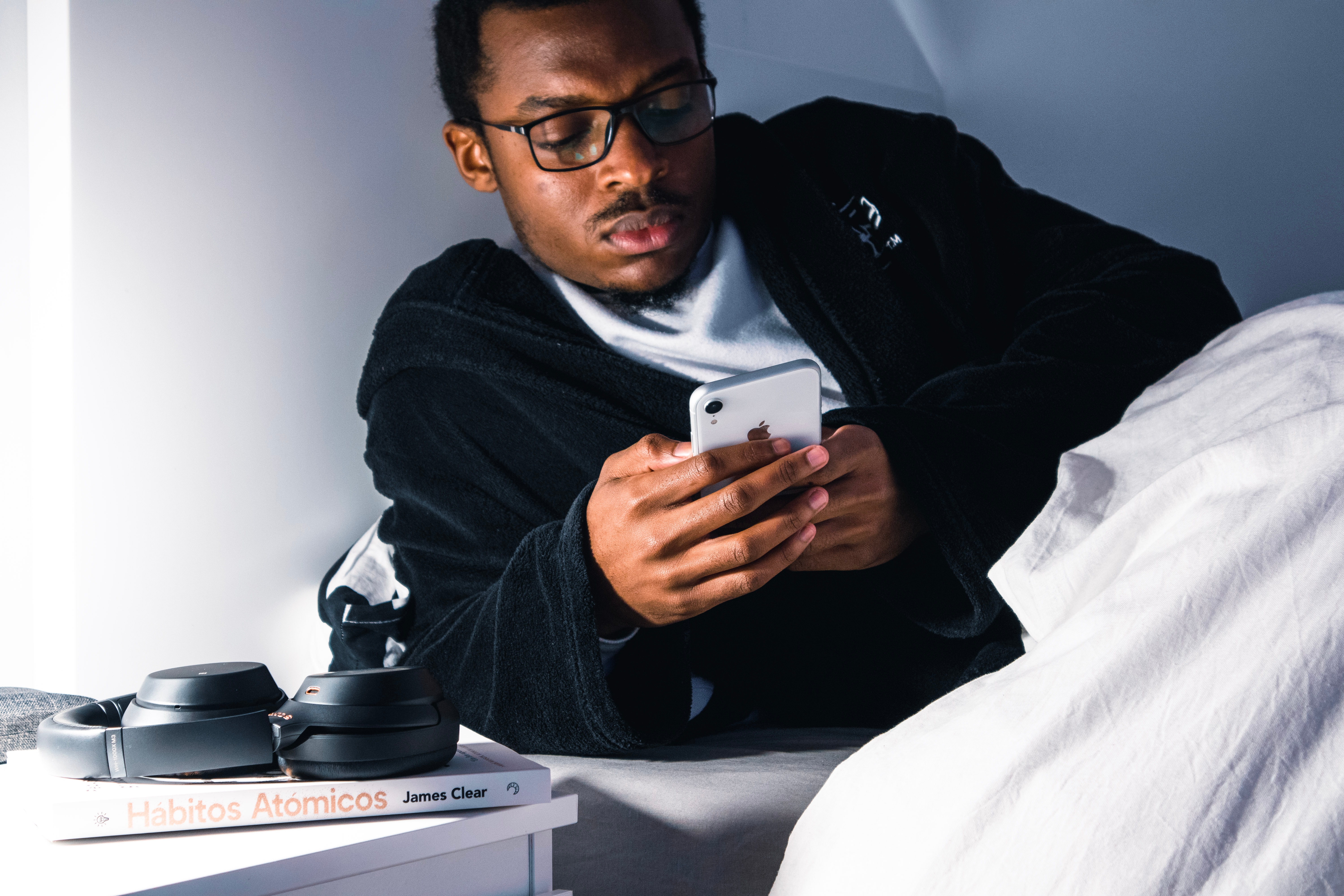 Man in bed looking at his cell phone.