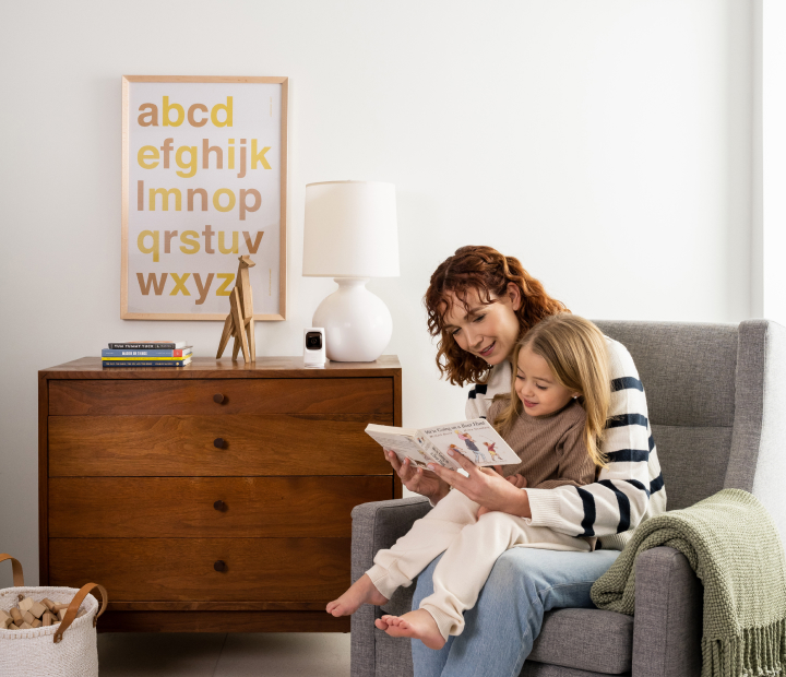 Indoor security camera watching a mom and child reading in the living room.