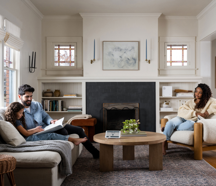 Family sitting in the living room in front of a fireplace.