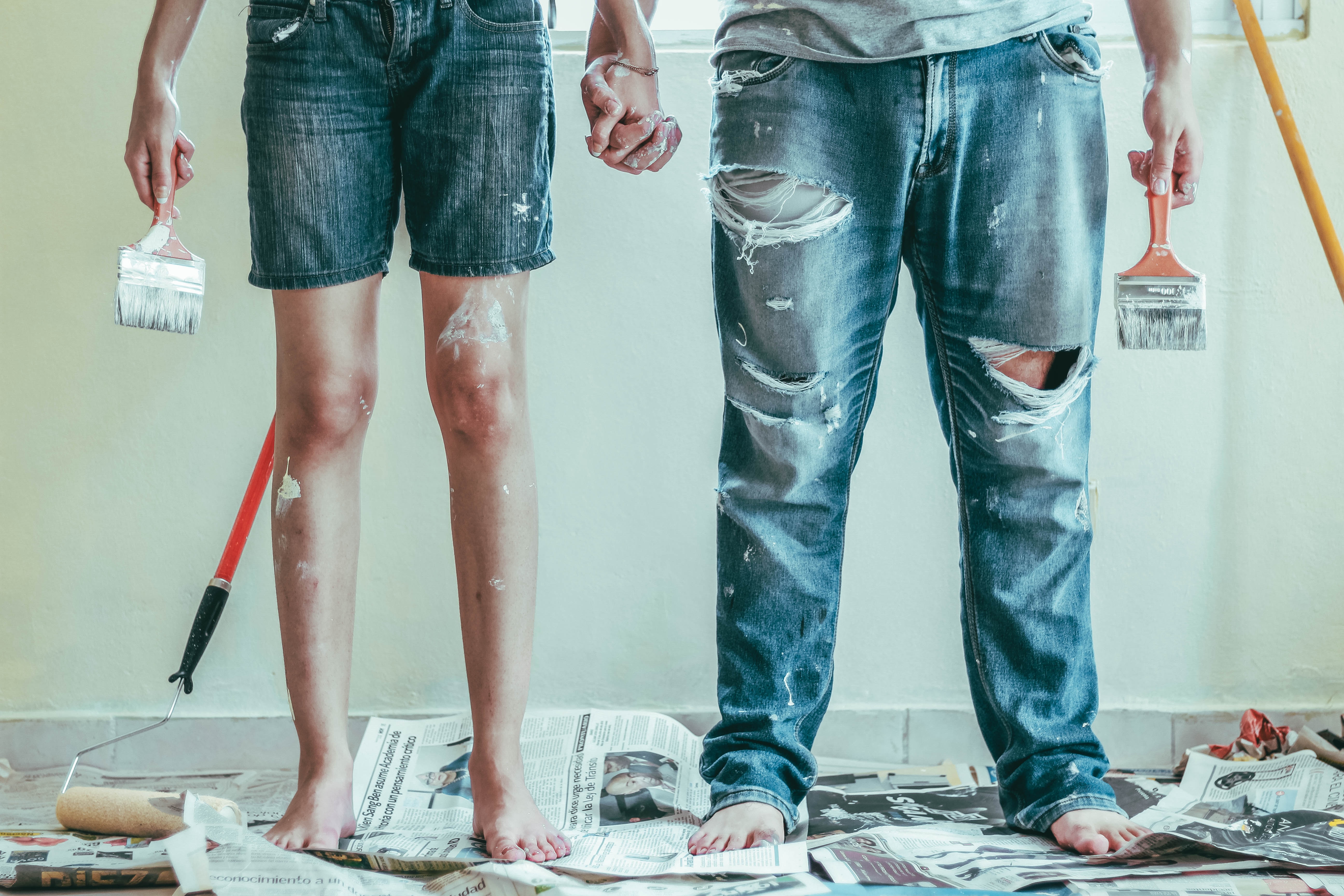 Man and woman working on a DIY painting project in their home.