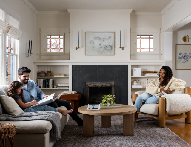 Family sitting in the living room in front of a fireplace.