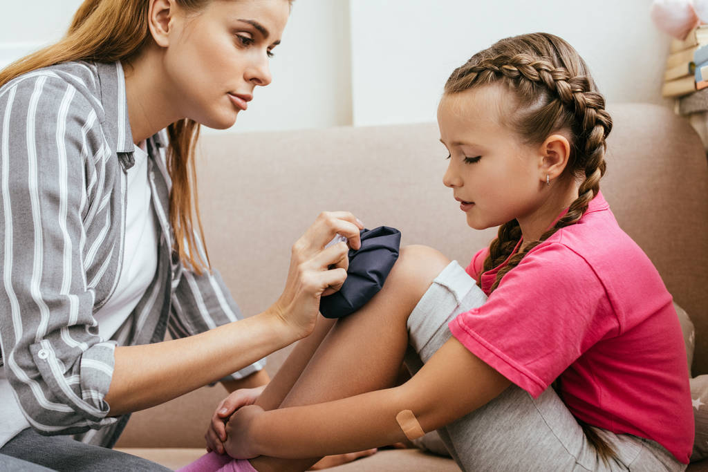 Mom administering first aid to her injured child.